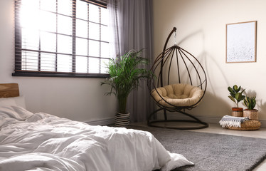Comfortable swing chair with pillow in bedroom interior