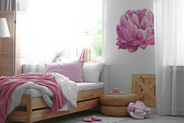 Stylish room interior with comfortable bed near decorated wall
