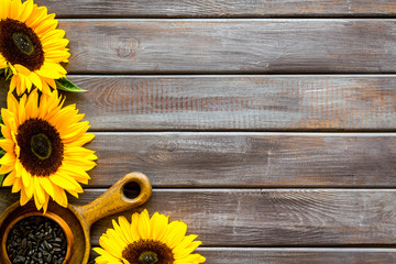 Frame of sunflowers and seeds on wooden background top view mockup