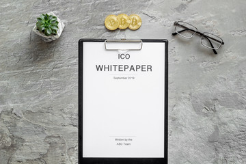 Initial coin offering ICO white paper on gray textured background top view