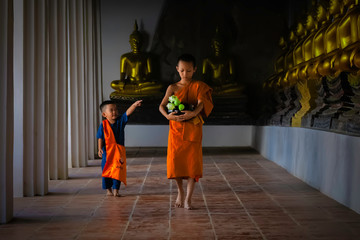 Asian novice monk walking in temple phutthaisawan at Ayutthaya, Thailand..