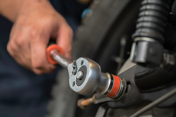 Fototapeta premium Image is Close up,People are repairing a motorcycle Use a wrench and a screwdriver to work.