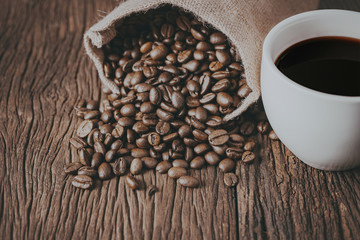 Roasted coffee beans on wooden background. Selective focus. Vintage stlye.