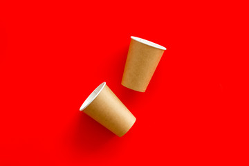 Empty paper cups for coffee to-go from cafe on red background top view mock-up