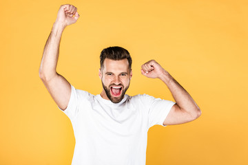 Fototapeta premium happy handsome man in white t-shirt showing yes gesture isolated on yellow