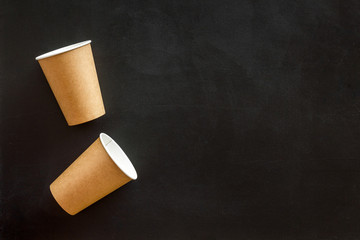 Empty paper cups for coffee to-go from cafe on black background top view copyspace