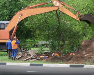 Road construction equipment and workers on the highway.  Tractors, on the road repair site.  Road repair concept.