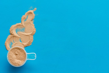 Nutrition for workout with protein cocktail powder on blue background top view mockup
