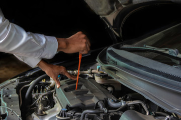 A mechanic Check the oil. Work equipment such as glove.Concept Service by car..
