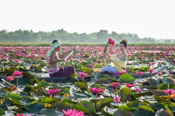 Wandcirkels aluminium Asian Men are collecting red lotus flowers for Asian women to worship. The culture of the Thai people.. © Suppasit