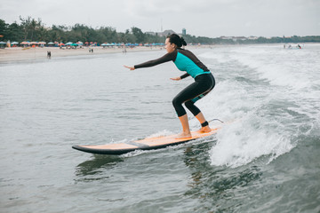 Surfer girl walking with board on the sandy beach. Surfer female.Beautiful young woman at the beach. water sports. Healthy Active Lifestyle. Surfing. Summer Vacation. Extreme Sport. Tattoo woman, Bali