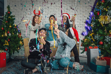 Fototapeta premium group of asian friends having fun with confitti at new years or christmas celebration party at home