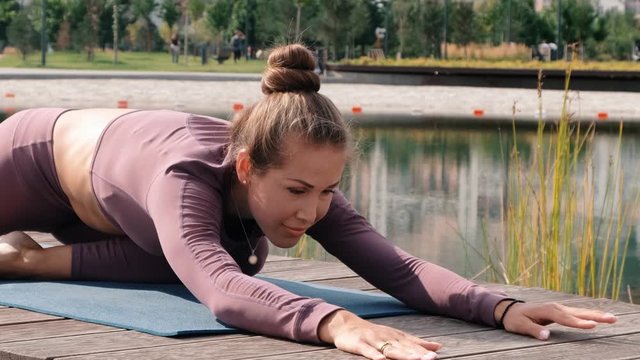 Young woman doing yoga exercises with city on background. eka pada rajakapotasana. Pigeon pose