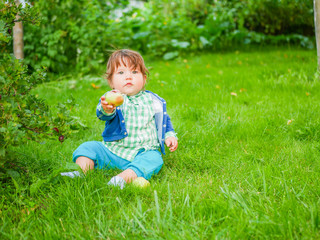 Baby and nutrition concept. Healthy Street Fun for Kids. Kid eats a pear on the grass. natural food