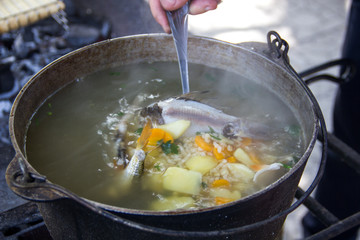 cauldron with an ear at the stake. Fish, potatoes, carrots in a spoon.Ear.Fresh-soup