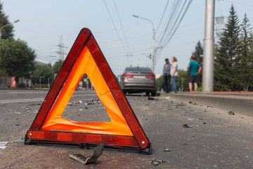 car accident on a city street, road warning triangle sign