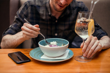 Young beard man posing in cafe, eating salad, healthy food,