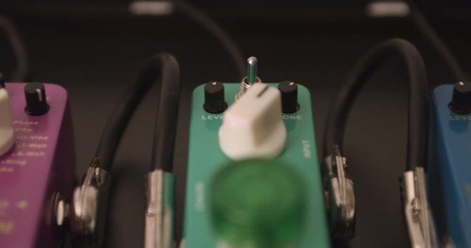 Multiple Colorful Guitar Effect Pedals. Camera Slowly Panning. Music Related 4K Concept