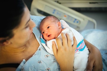 Newborn being held by mother in hospital