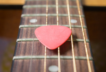 Red Pick on Acoustic Guitar String in Zoom View