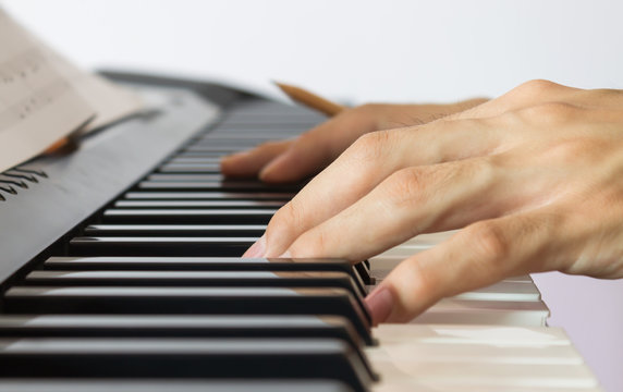 Piano Player Hand on Electric Piano with Sheet music