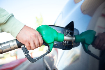 Man filling gasoline fuel in car holding pump