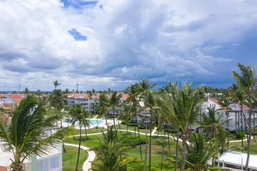 Aerial view from drone on caribbean houses with swimming pool in coconut palm tree garden