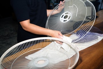 Fototapeta na wymiar Housekeeper use white cloth Wipe and clean the electric fan.