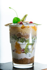 vertical view on healthy cream and fruits dessert in glass