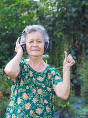 Senior woman listen music from wireless headphone