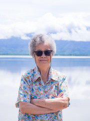 Senior woman standing and smile at side the lake