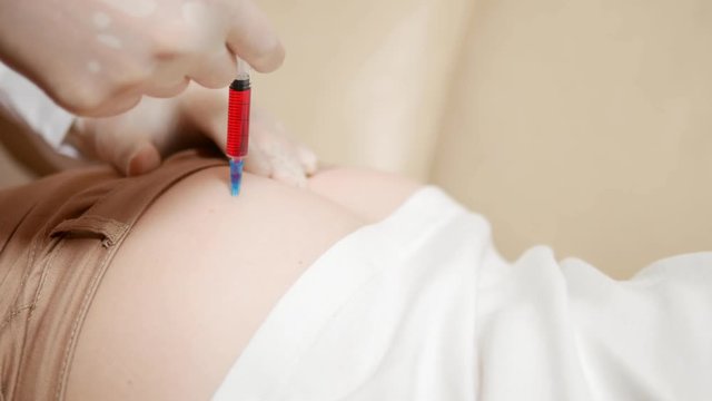 close-up, the doctor puts an injection into the buttock of the patient.