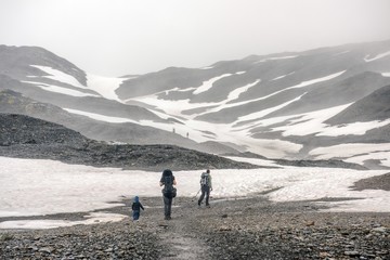 A family hiking up a mountain in the fog