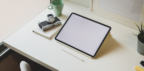 Trendy photographer workplace with blank screen tablet