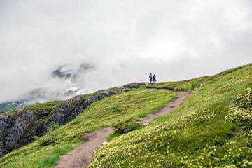 A couple on a trail looking out at the view in the mountains