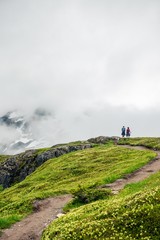 Obraz premium A couple on a trail looking out at the view in the mountains