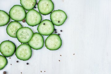 Flat lay composition of chopped green cucumbers. Top view, copy space for text.