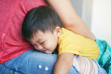 asian boy and mom hugging.