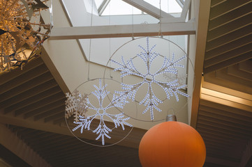 New Year and Christmas ceiling decorations in the mall. decoration with huge snowflakes to create a...