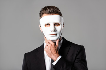 mysterious businessman in white mask isolated on grey