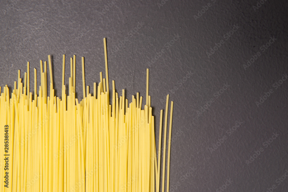 Poster Raw Italian spaghetti pasta on gray background