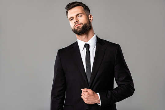confident stylish handsome businessman in black suit isolated on grey