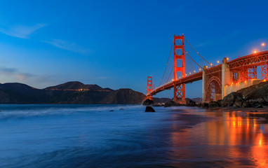 Golden Gate Bridge view from the hidden and secluded rocky Marshall's Beach at sunset in San Francisco, California