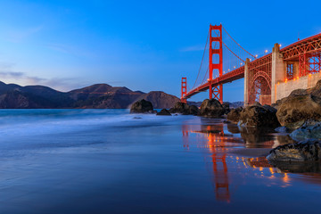 Golden Gate Bridge view from the hidden and secluded rocky Marshall's Beach at sunset in San Francisco, California