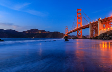 Golden Gate Bridge view from the hidden and secluded rocky Marshall's Beach at sunset in San Francisco, California