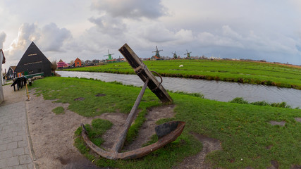 Big anchor in the foreground and windmills in the background at Zaanse Schans, Netherlands
