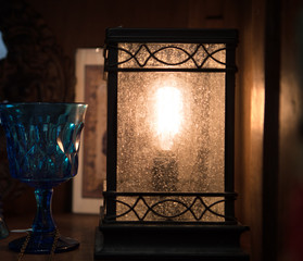 Fototapeta na wymiar Lantern with Blue wine glass illuminated by light from lantern