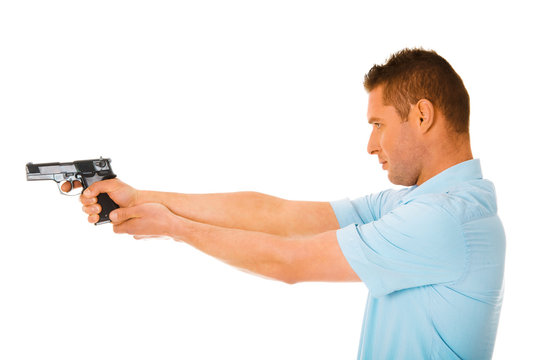 Side view on man holding gun and aiming, isolated on white background.