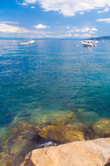 Adriatic sea with stones and boats in Croatia