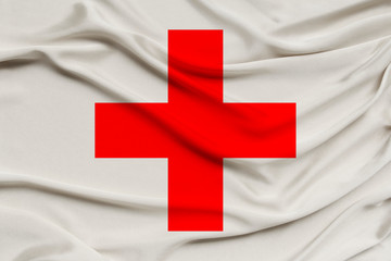 silk flag of organization red cross, crescent, close-up, copy space